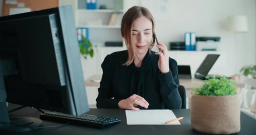 Smiling Businesswoman Talking on Smartphone in Office