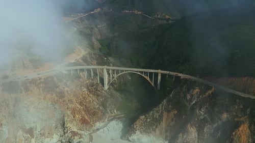 Bixby Bridge at Big Sur, famous Highway One in California with fog. Aerial.