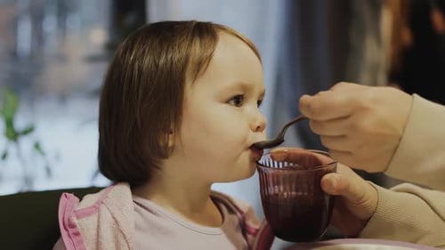 Child Being Fed at Table Indoors During the Day