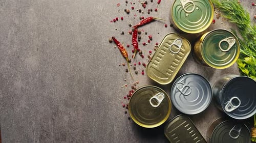 Latas de metal con comida enlatada o paté, vista desde arriba, latas doradas y plateadas con anillos para tirar, enlatadas