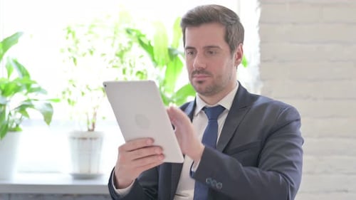 Young Businessman Using Digital Tablet in Office