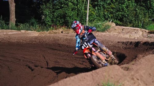 Motocross Racer Passing Curvy Turn on Dirt Track in slow motion in Berlin Competition