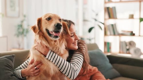 Woman Hugging Golden Retriever on Couch at Home