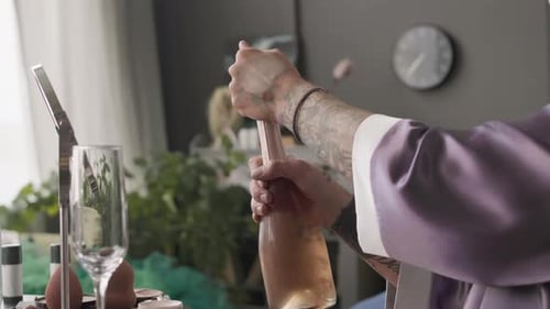 Queer Man Opening Bottle of Sparkling Wine at Home