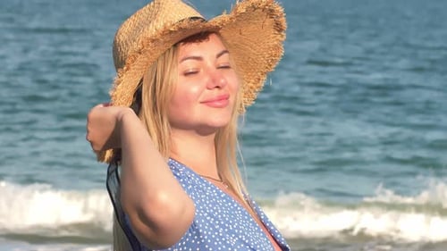 Blonde Woman in Hat Posing on Sunny Beach