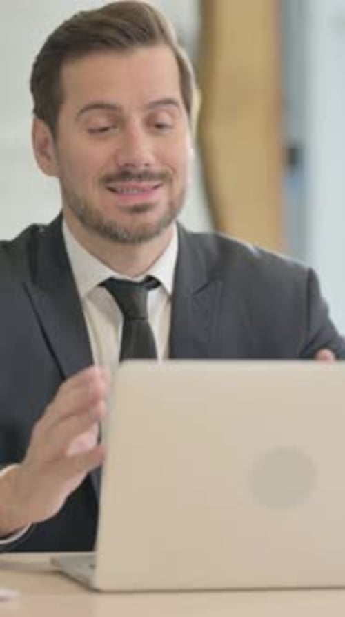 Adult Man Talking in Front of a Laptop