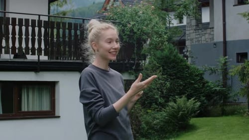 Woman Smiling and Holding Keys in Garden