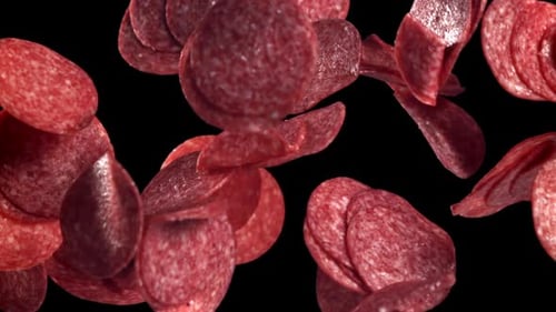 Pepperoni Slices Falling on a Black Background