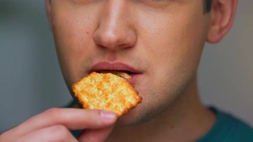 Face Portrait of Adult Man Eating Food of Sweet Cookie in CloseUp Studio Shot