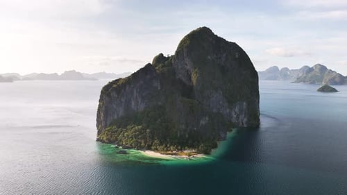 Towering limestone cliffs rise over turquoise waters on Pinagbuyutan Island, Palawan, Philippines
