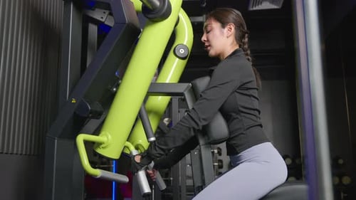 Portrait of Beautiful Asian Young Woman Performing Squats on a Gym Machine Female Working Out with