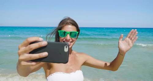 a girl phone to the sea and communicate with friends and relatives thanks to her smartphone, conne