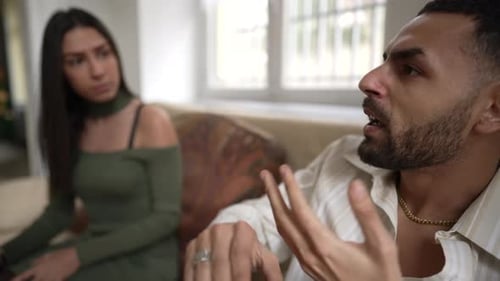 Couple fighting arguing problems about relationship while sitting on couch at home. Angry