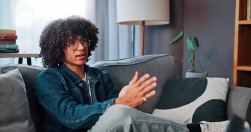 Young Man Talking on Sofa in Living Room