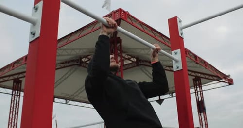 Training Motivation Athlete Man Working Out Outside on the Outdoor Gym Making Pull Ups Strong Fit