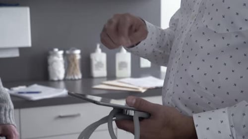Doctor Uses Tablet with Stethoscope in Medical Office