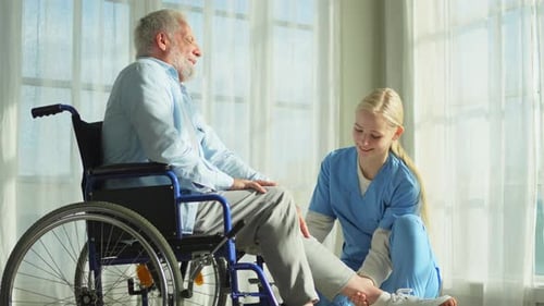 Senior Man Receives Leg Massage From a Caregiver