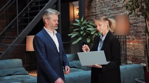 Businessman and Businesswoman Discuss Project, Shake Hands