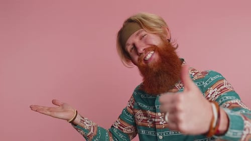 Hippie Man Showing Thumbs Up and Pointing Empty Place Advertising Area for Commercial Text Promotion