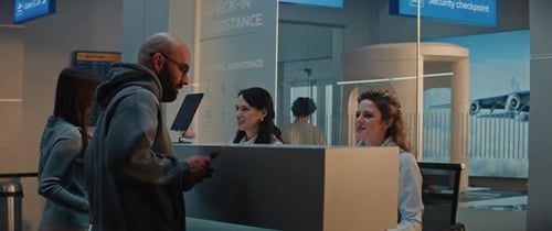 Male Passenger Giving Passport and Flight Ticket to Female Airline Agent at Airport Checkin Counter