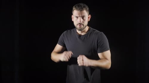 Man Boxing and Shadow Boxing Against Black Backdrop