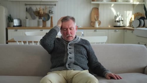 Senior Man Experiencing Headache at Home