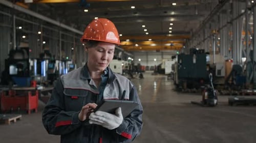 Supervisora madura usando una tableta en una fábrica de metalurgia