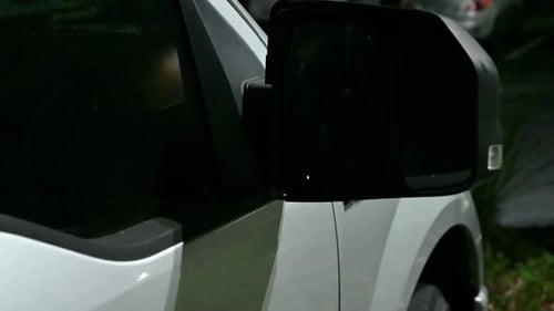 flashing police lights during a traffic stop, side view of a pickup truck and mirror