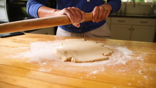 Adult Rolling Dough in Sunny Kitchen