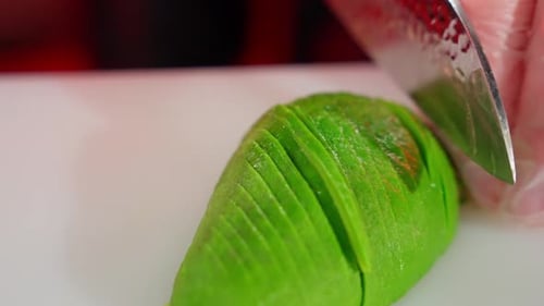 Close-up of Hands Slicing Fresh Avocado