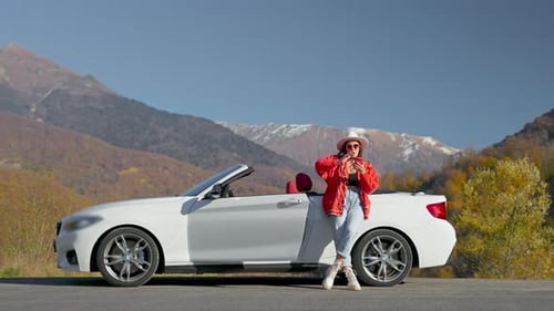 Happy Tourist Woman Filming Herself By Smartphone in Mountain Landscape Standing Near Cabriolet