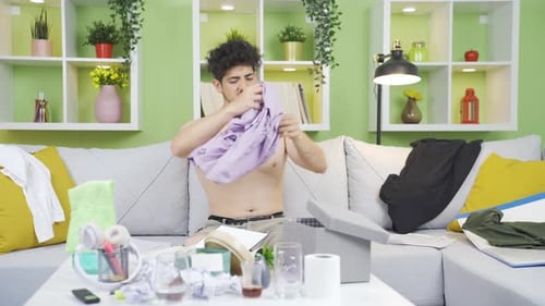 Young Adult Puts on Shirt and Reads at Home