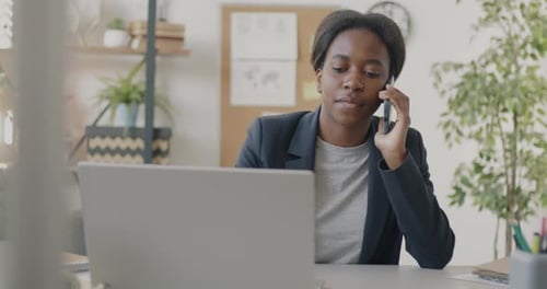 Young Adult Working at Desk Answering Phone