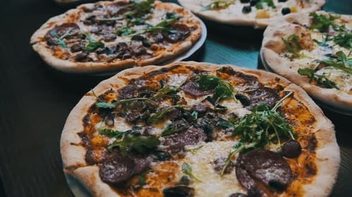 Lots of Pizzas on the Table in a Pizzeria