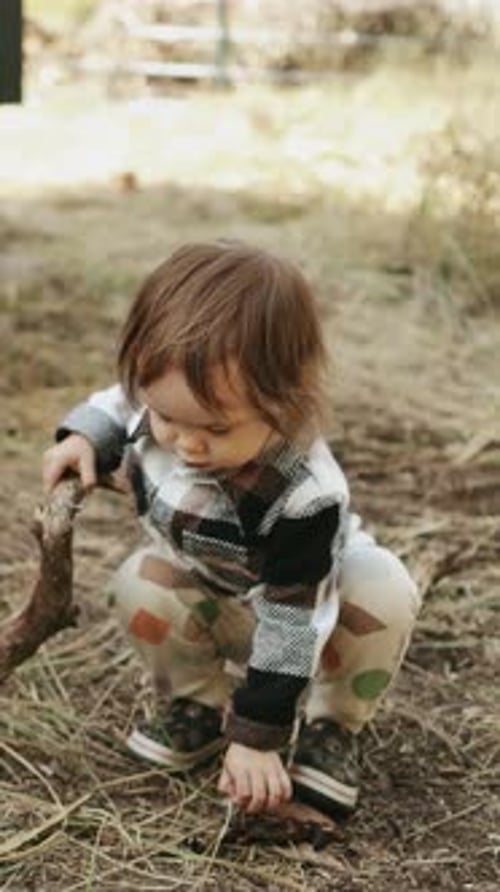 Cute Child Playing with a Stick in Nature