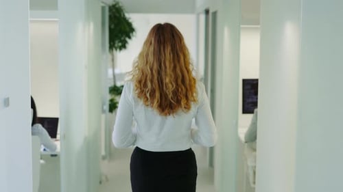 Back View of Woman Going Through the Corridor in Office Building