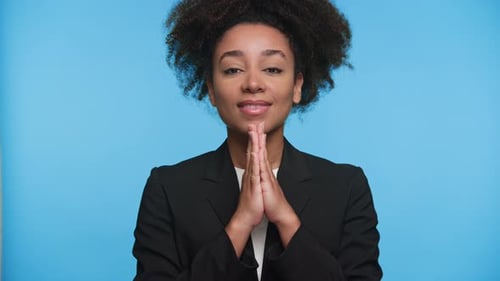 Peaceful Businesswoman with Hands in Prayer Pose and Eyes Closed