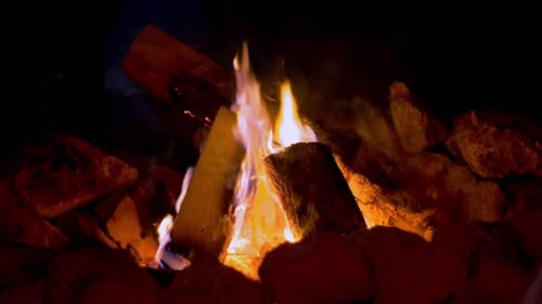 Campfire burning at night among rocks