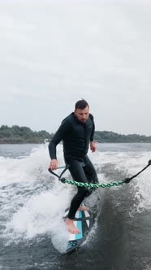 Two Surfers Perfecting Their Skills on the Water Cutting Through the Waves in a Dynamic Surfing
