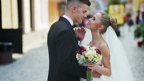 Young Beautiful Bride and Groom on the Wedding Walk Through the Streets
