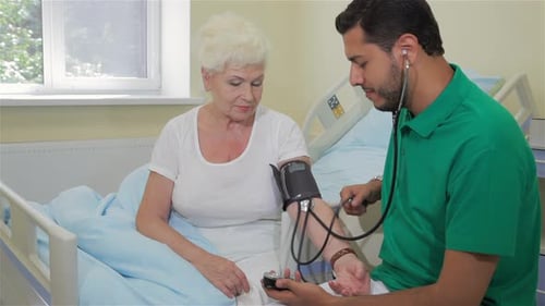 Senior Woman Getting Blood Pressure Checked by Doctor