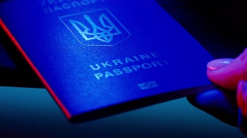 Close Up Shot of Person Identity Document Shot of Female Hand Placing Blue Ukrainian Passport with