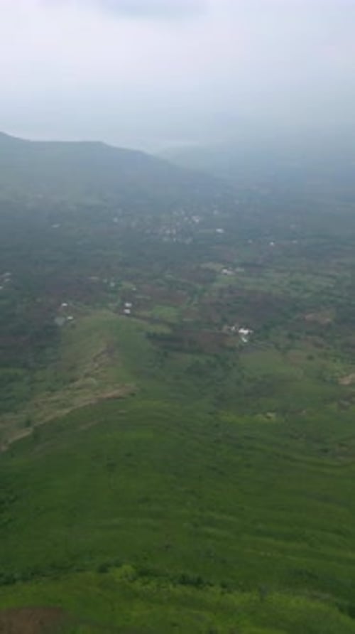 Vue par drone de l'autoroute Nashik-Trimbak au milieu d'une végétation luxuriante et de montagnes sous un ciel clair et brumeux