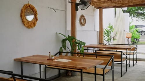 Empty Tropical Cafe with Wooden Tables Exotic Plants Outdoor Dining Area in Daylight Quiet Ambiance