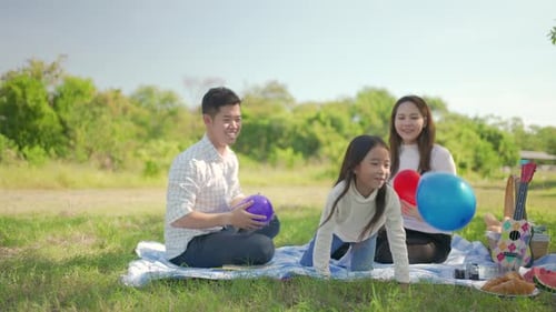 Happy Family Picnic Outdoors Playing with Balloons
