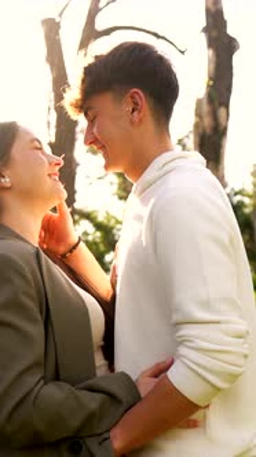Happy Couple Embraces and Kisses in Park