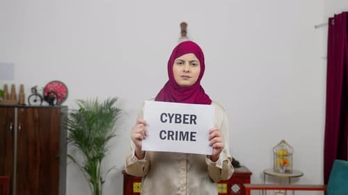 Woman Holding Cyber Crime Sign in Home