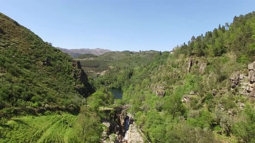 Flying Over River Rocks on the Mountains Covered by Green Forest. Environment Concept