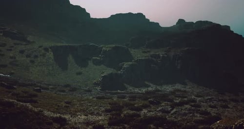 Rugged Mountain Landscape Shrouded in Mist During Twilight Hours