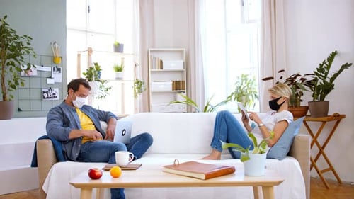 Couple Working on Separate Sides of Couch